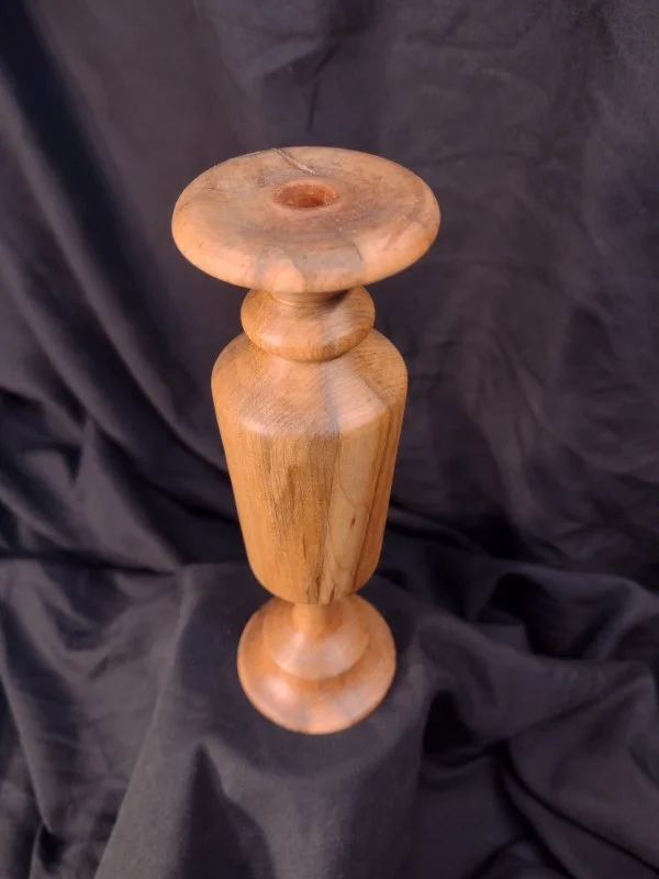 Turned wood with unique shape and central hole.