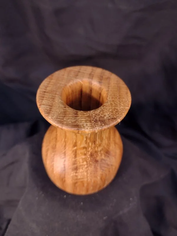 Turned wood with unique shape and central hole.