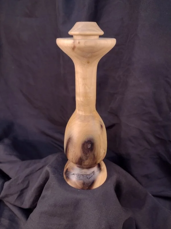 Turned wood with unique shape and central hole.
