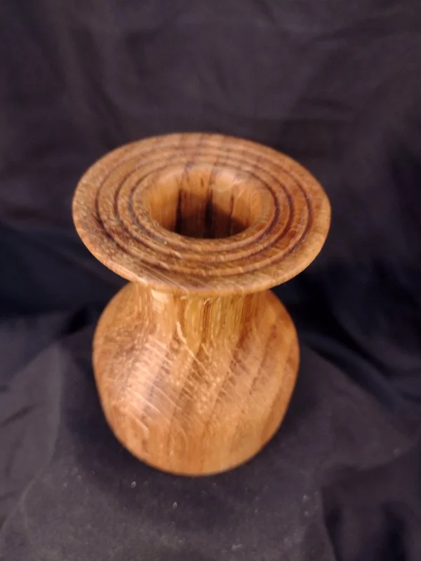 Turned wood with unique shape and central hole.