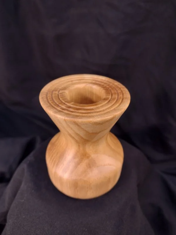 Turned wood with unique shape and central hole.