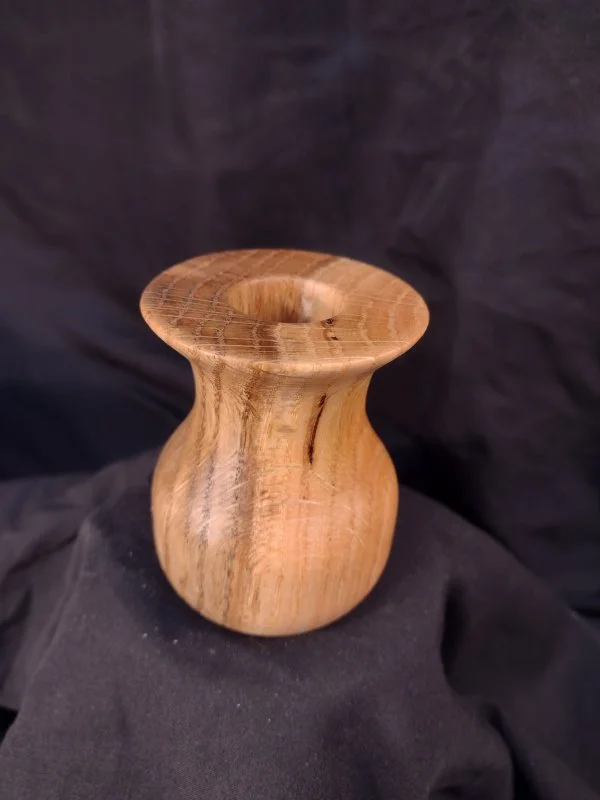 A small wooden vase with a rounded body and a flared, slightly ridged opening.