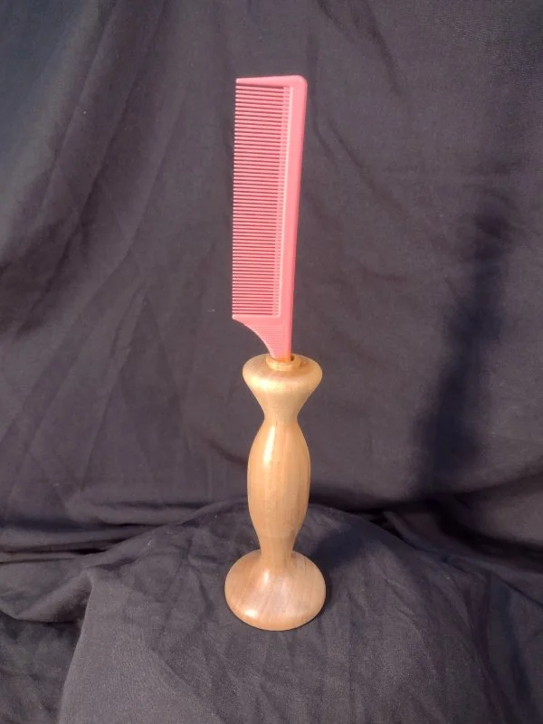 A wood handled comb that sits upright.
