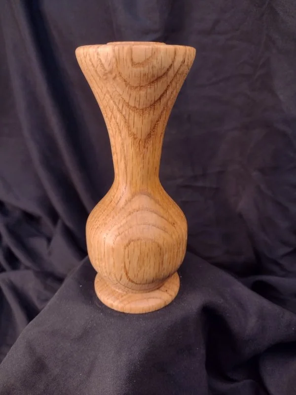 Turned wood with unique shape and central hole.