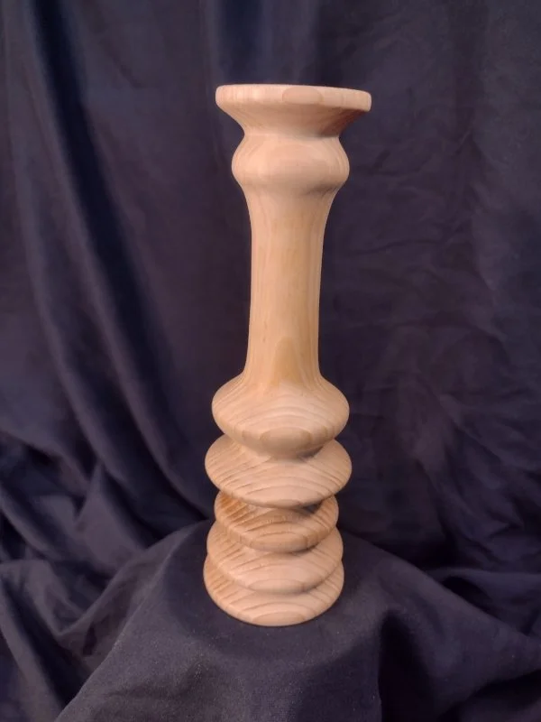 Turned wood with unique shape and central hole.