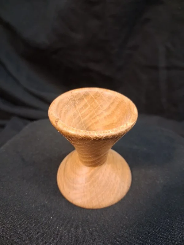 A small wooden rounded bowl and a narrow stem.