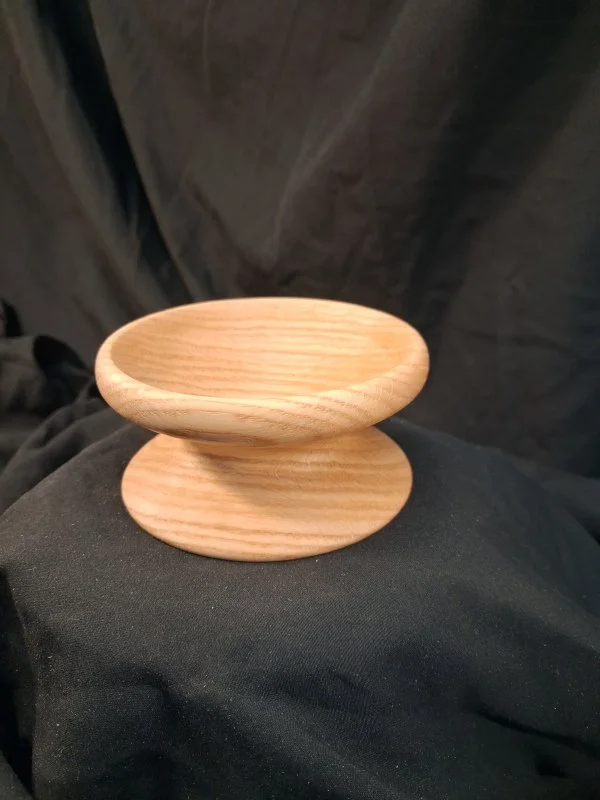 A small wooden bowl with a rounded shape.
