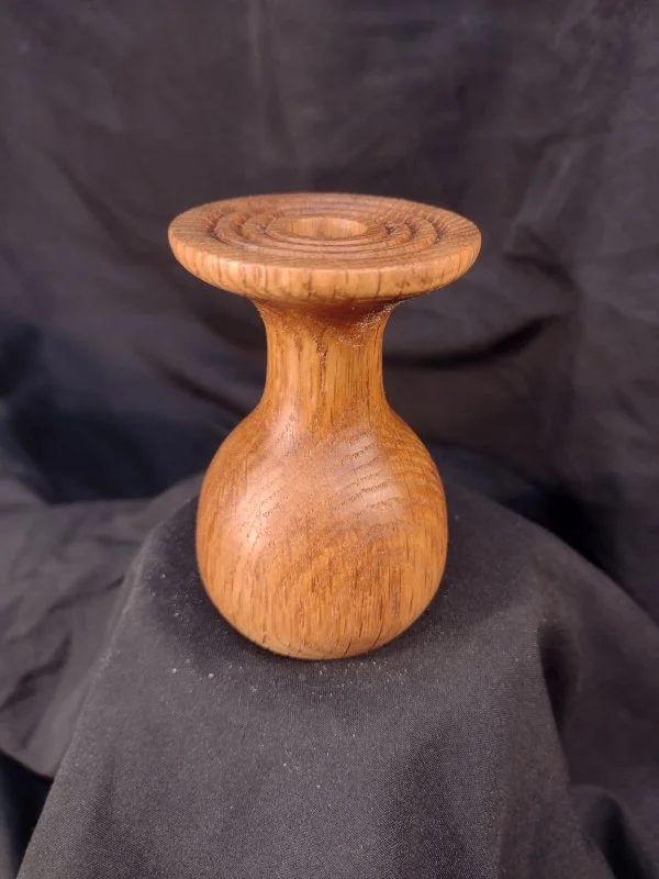 Turned wood with unique shape and central hole.