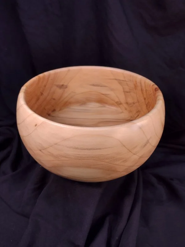 A turned wood bowl with beautiful grain and color with a natural finish.