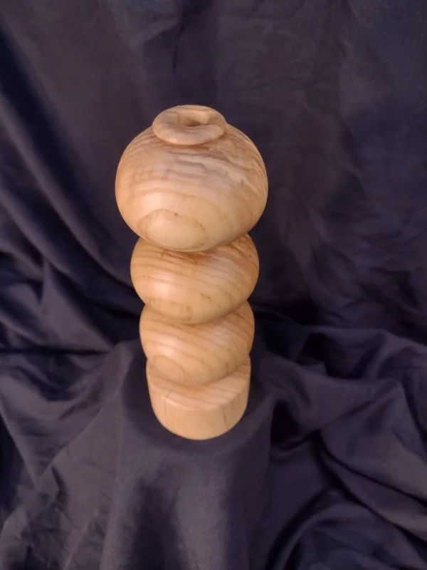 Turned wood with unique shape and central hole.