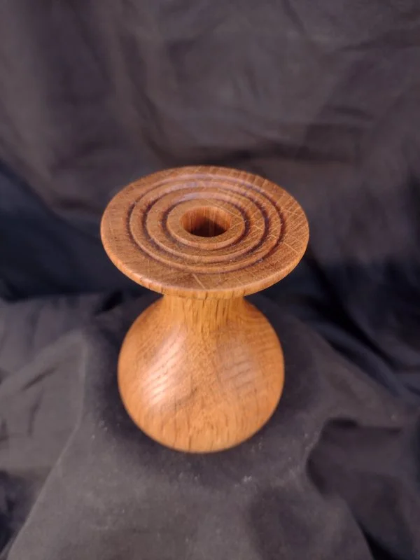 Turned wood with unique shape and central hole.