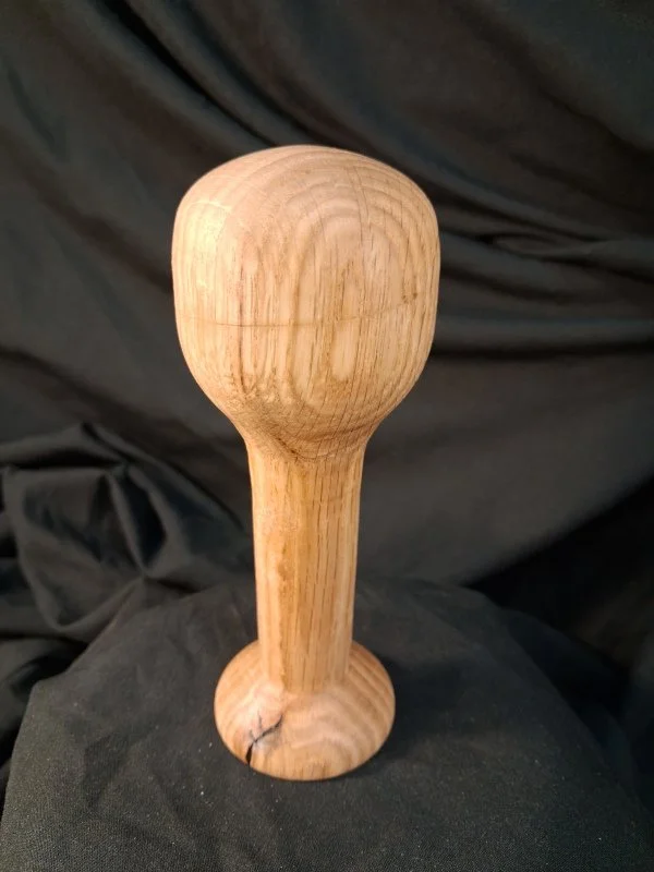 A wooden mallet with a rounded head and a short handle.