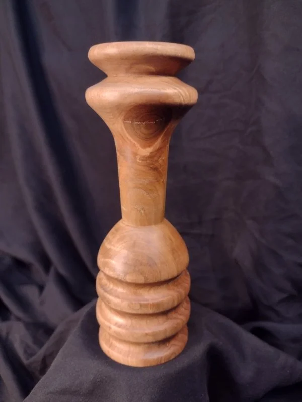 Turned wood with unique shape and central hole.