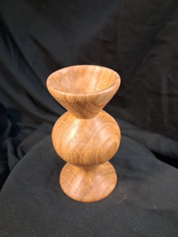 Wood vessel with a wide bowl at the top, a spherical middle section, and a flat base.