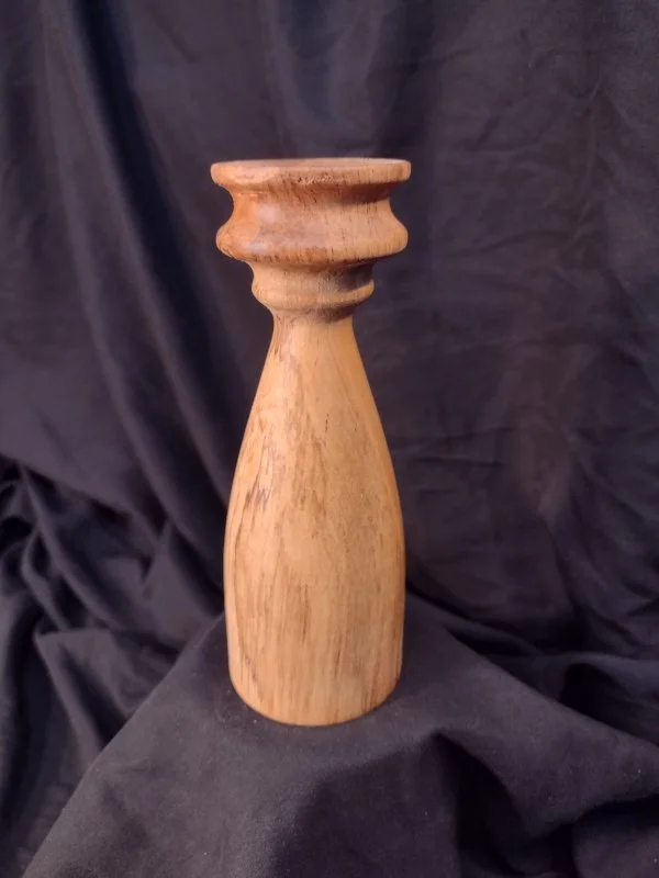 Turned wood with unique shape and central hole.