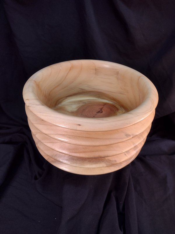 A turned wood bowl with beautiful grain and color with a natural finish.