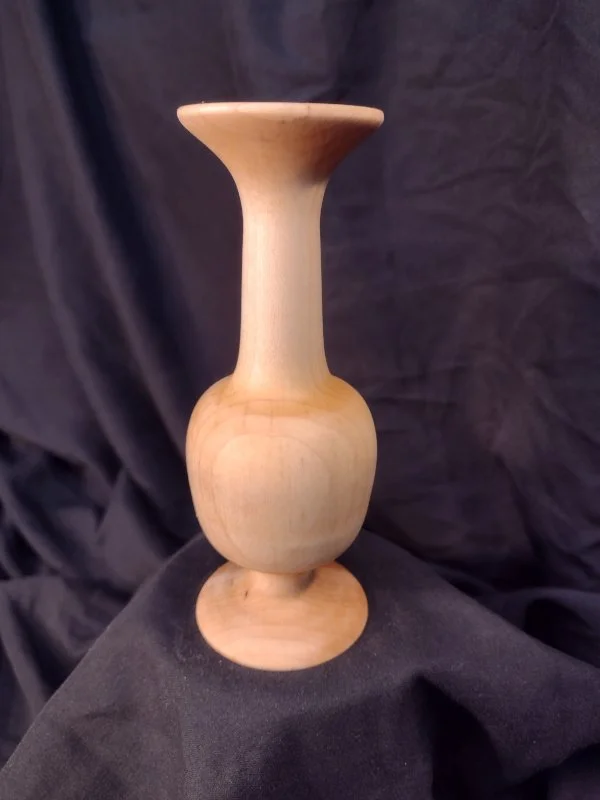 Turned wood with unique shape and central hole.