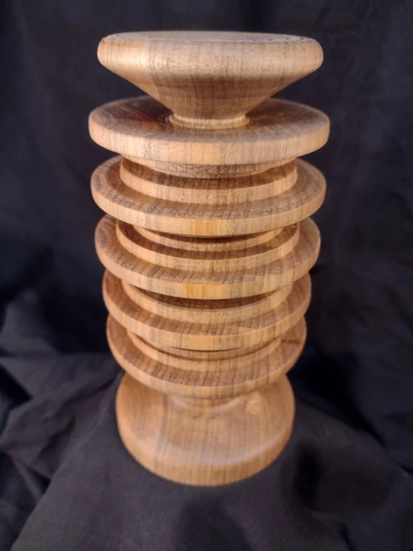 Turned wood with unique shape and central hole.