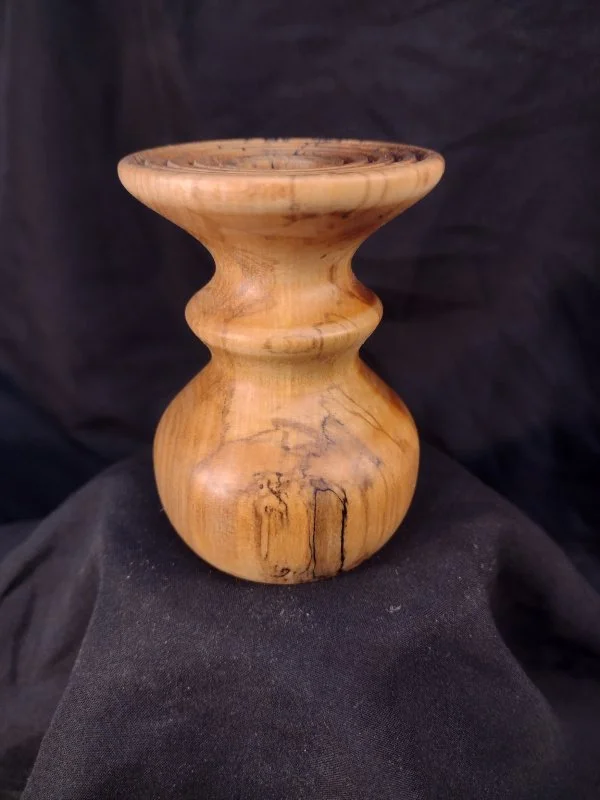 Turned wood with unique shape and central hole.