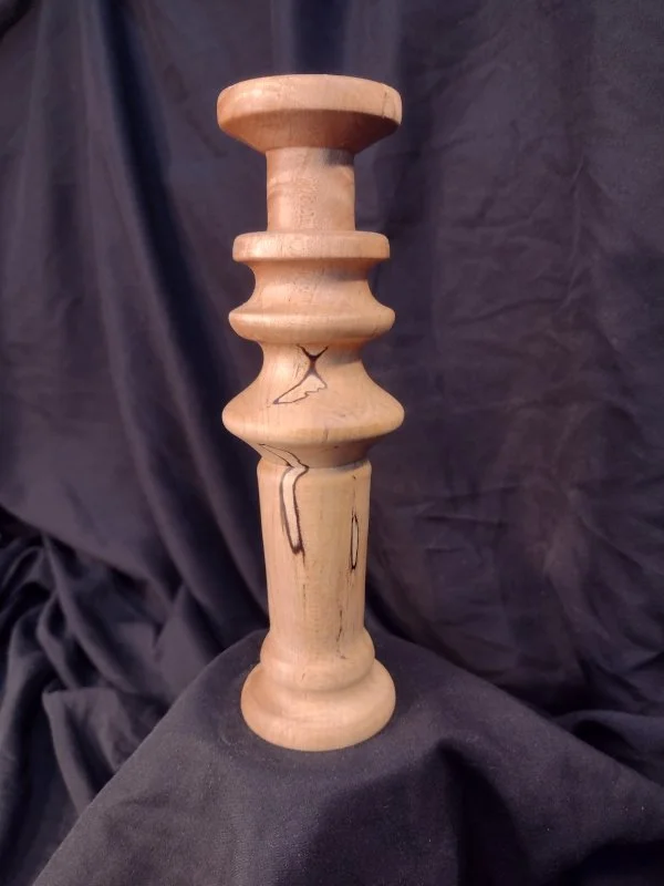 Turned wood with unique shape and central hole.