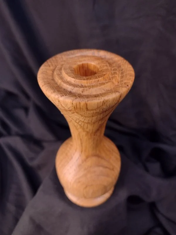 Turned wood with unique shape and central hole.