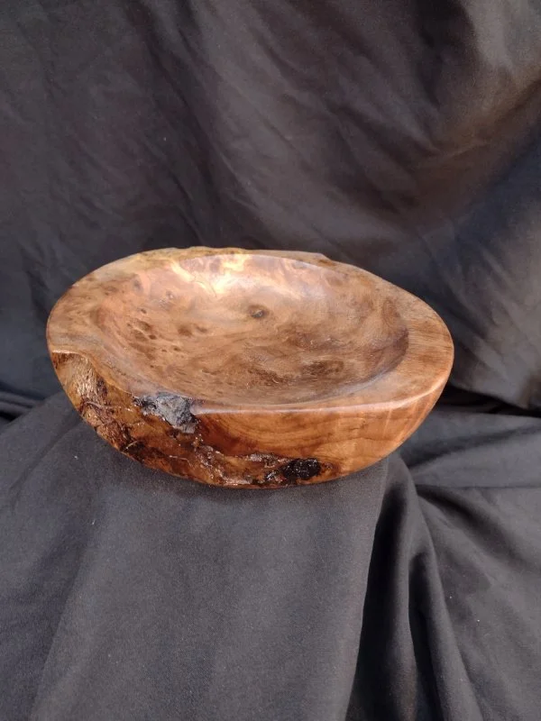 A turned wood bowl with beautiful grain and color with a natural finish.