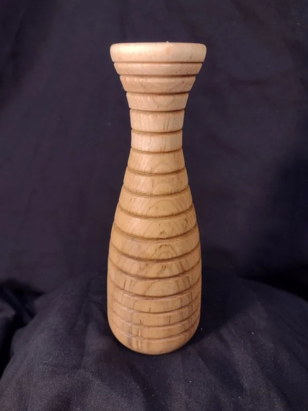 A wooden hourglass-shaped multiple stacked circular grooves.