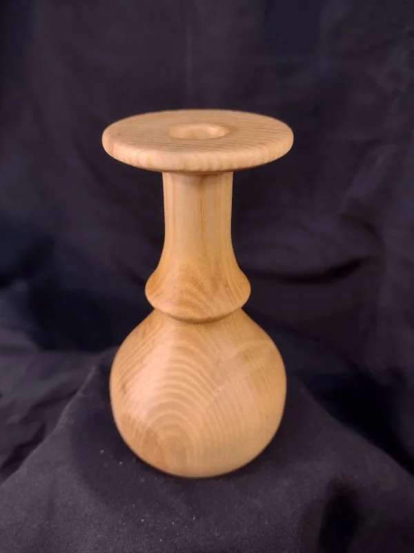 Turned wood with unique shape and central hole.