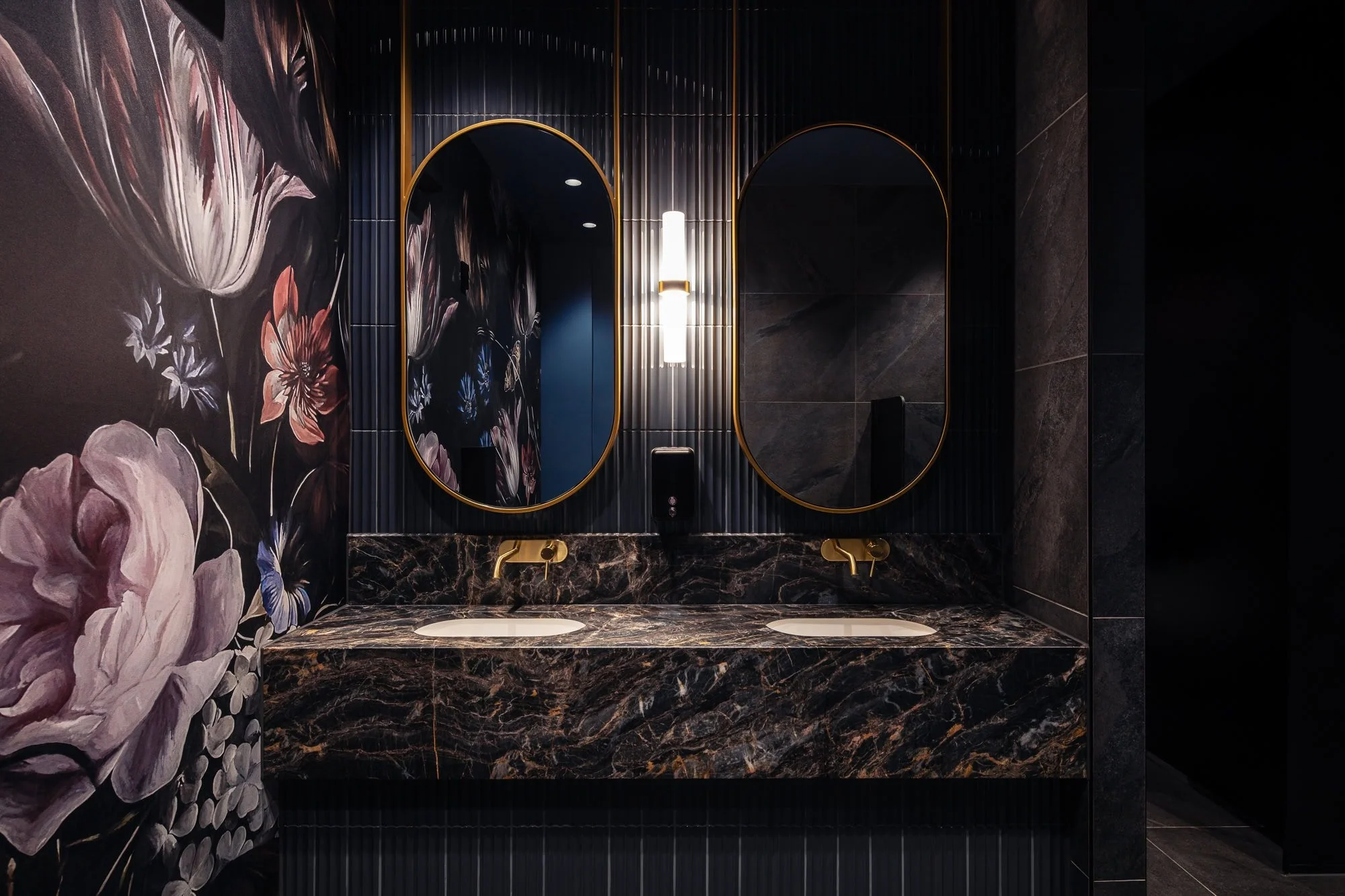 A luxurious bathroom vanity area with a dark theme