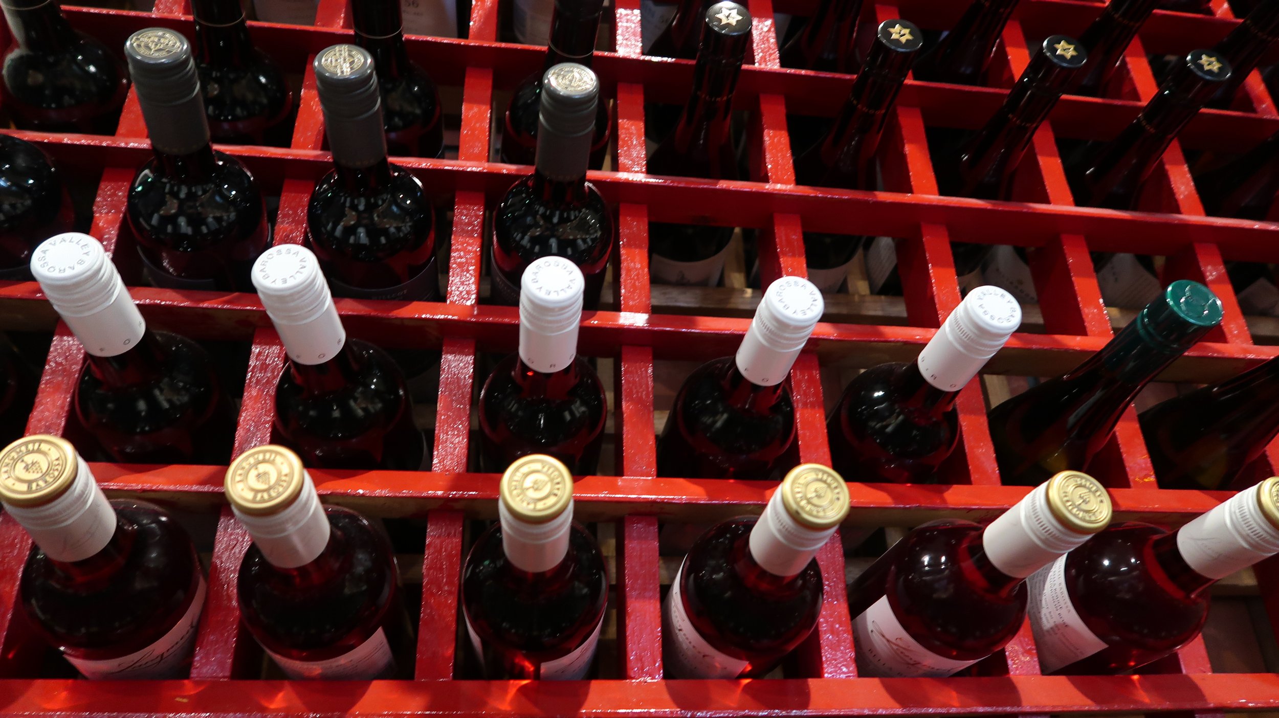 Red wine bottles stored in a red wine rack.