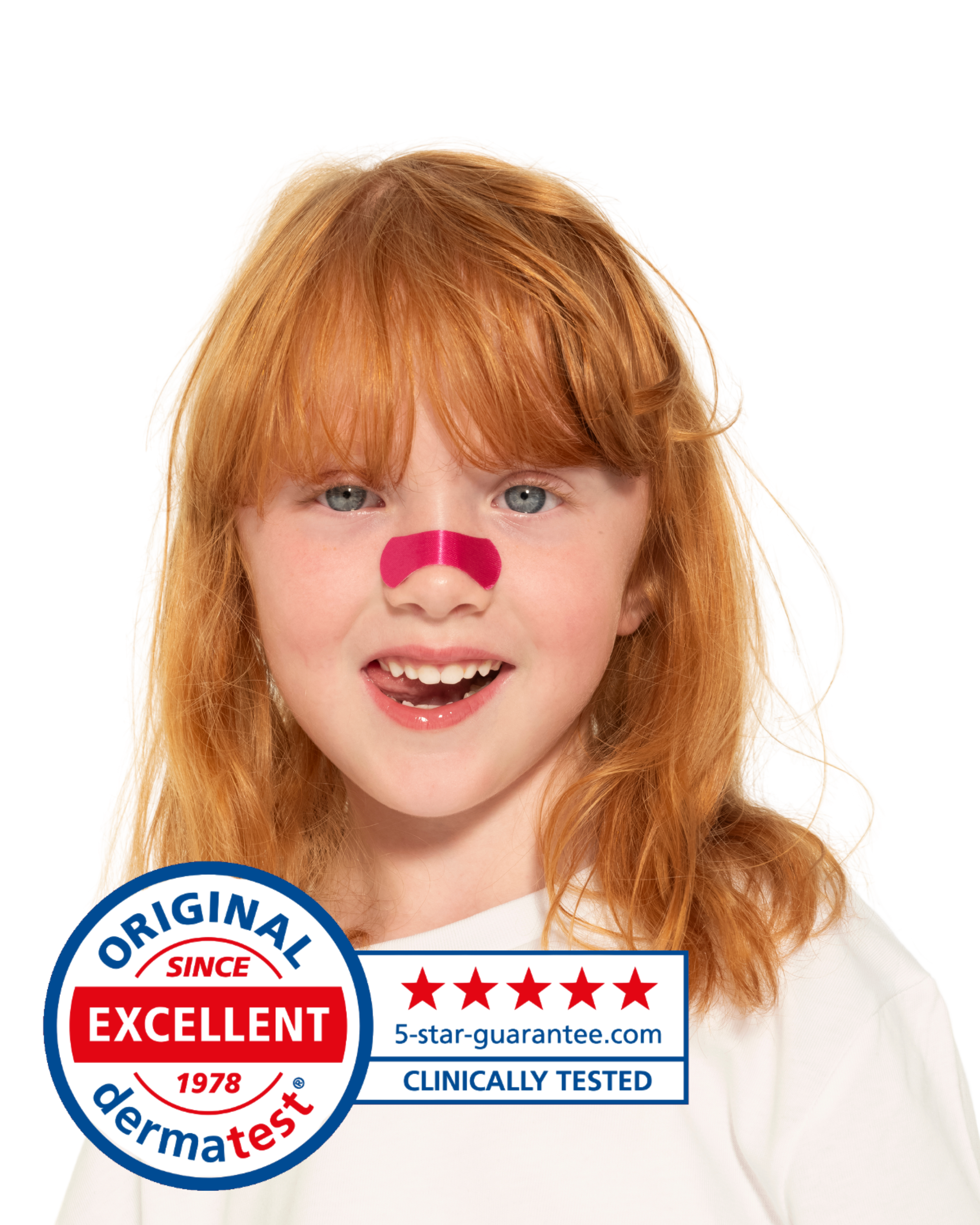 Ein lachendes Mädchen mit rotem Haar und blauer Augen, das eine rote Streifen-Nase trägt, vor einem weißen Hintergrund, mit einem Dermatest-Qualitätsstempel und Bewertungen auf dem Bild.