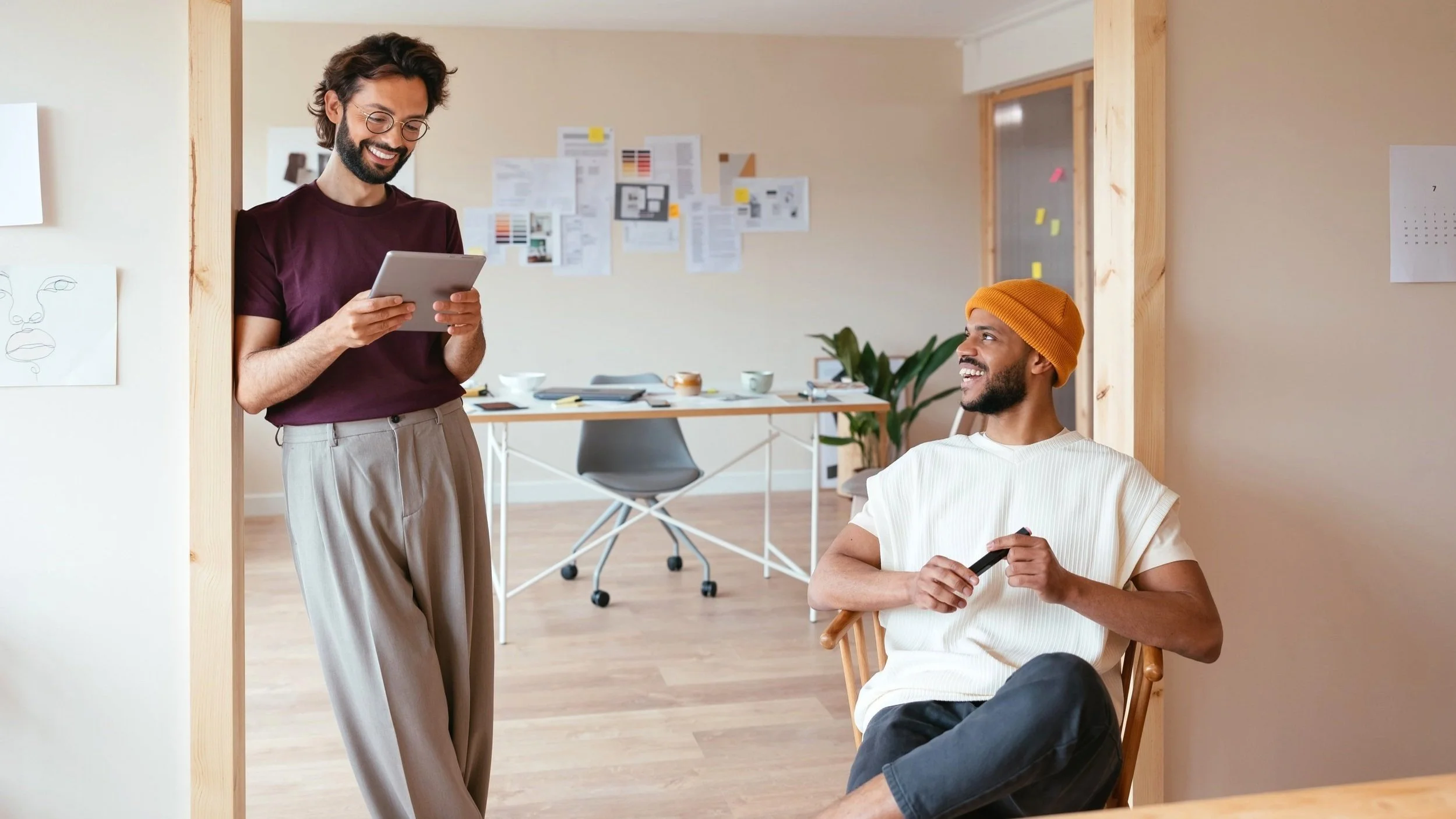 Hombres multirraciales analizando un proyecto en un lugar de trabajo creativo