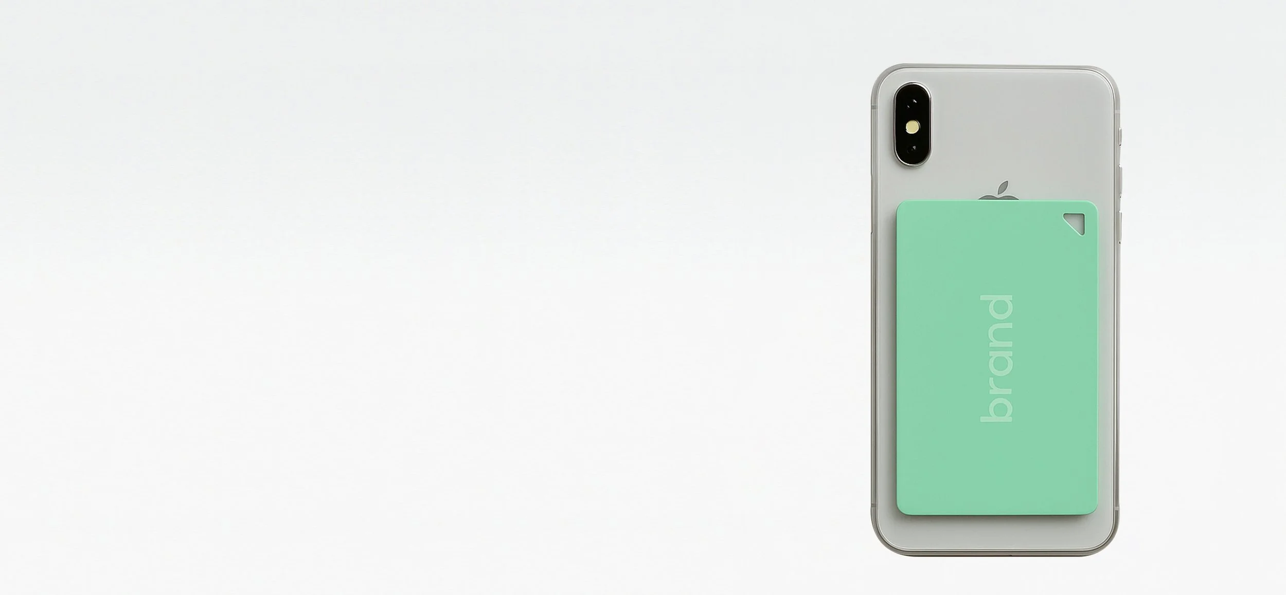 An iPhone with a transparent case and a green card with the word 'brand' on it, placed on the back of the phone.