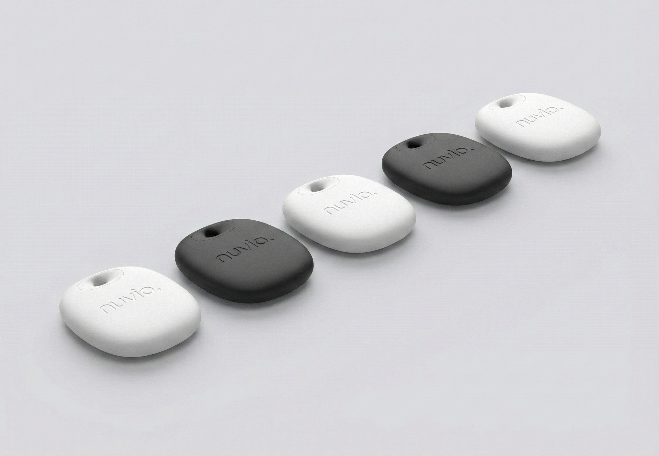 Five small, oval-shaped devices arranged in a diagonal line on a plain light gray background. The devices are in alternating black and white colors, with the word 'aluvio' engraved on each.