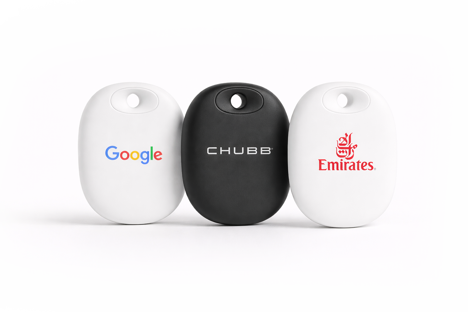 Three keychains with branding from Google, Chubb, and Emirates, placed side by side on a white background.
