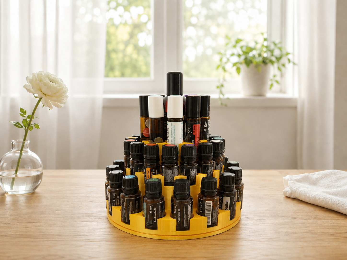 Suport etajat rotativ pentru uleiuri esențiale doTERRA EssenceGuard Grande culoarea gold, imprimat 3D, așezat pe o masă din lemn cu sticluțe și recipienți roll-on.