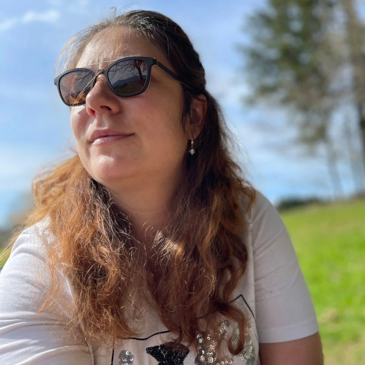 Portret luminos în natură al Elenei, fondatoarea Blooming Health. Atmosfera relaxantă din mijlocul verdelui reflectă legătura ei profundă cu practicile de wellness natural și o abordare clară, bazată pe știință, a uleiurilor esențiale pure.