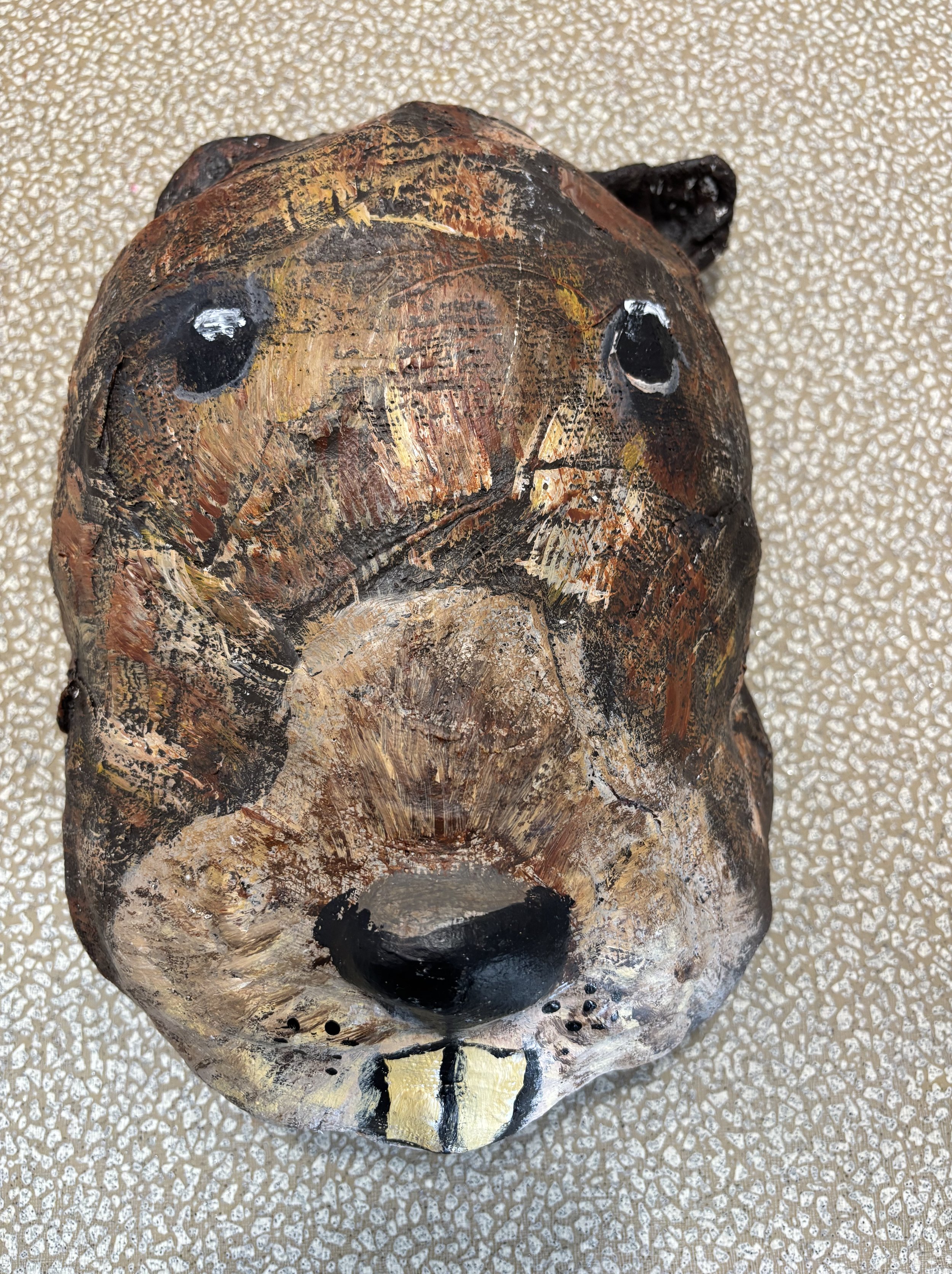 Charming handmade Beaver mask face with black eyes, black nose, and teeth made by a child.