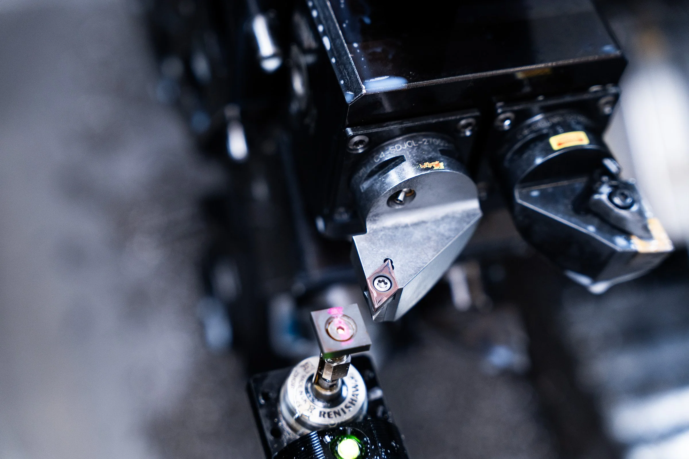 Nahaufnahme eines komplexen mechanischen Systems, wahrscheinlich im Zusammenhang mit Luft- oder Raumfahrttechnik, mit mehreren schwarzen und metallischen Komponenten, inklusive Dreh- und Verschlusselementen.