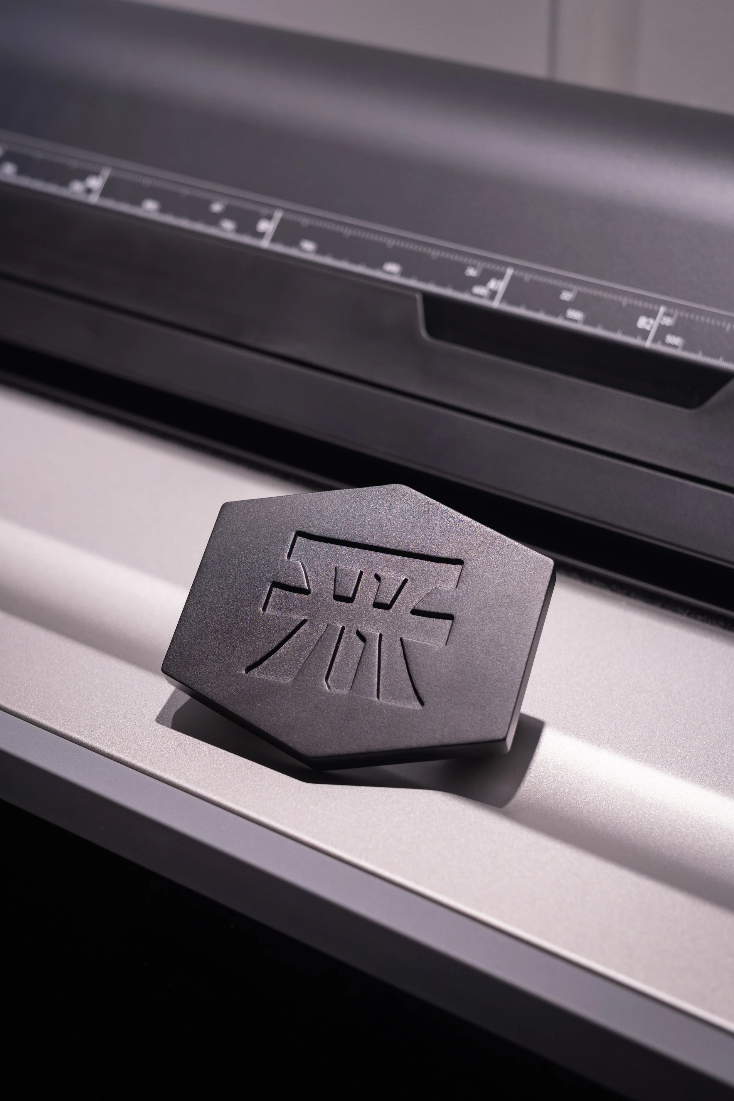 A close-up of a Zund cutting machine with a black Zund branded tool placed on the machine's surface.