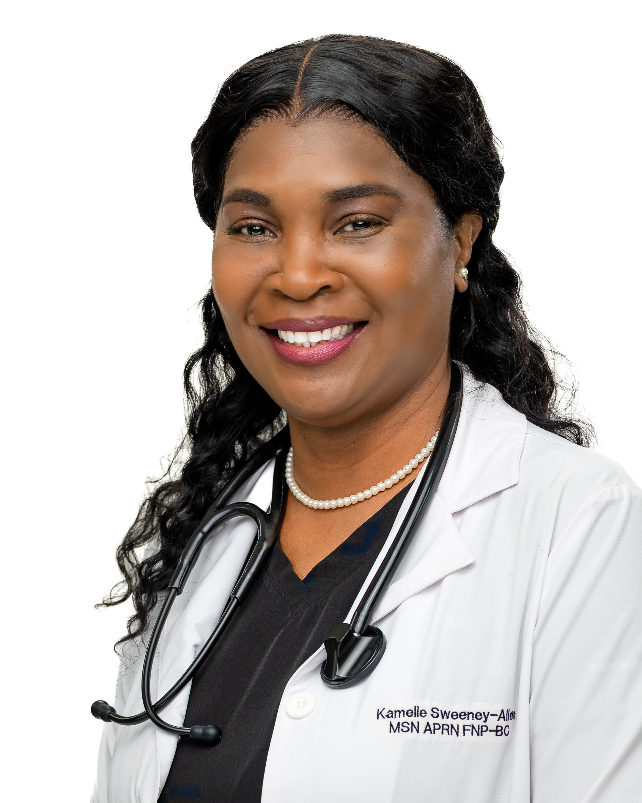 A smiling African American female doctor wearing a white lab coat with a stethoscope around her neck and pearl necklace. She has long curly black hair and is wearing earrings and lipstick.