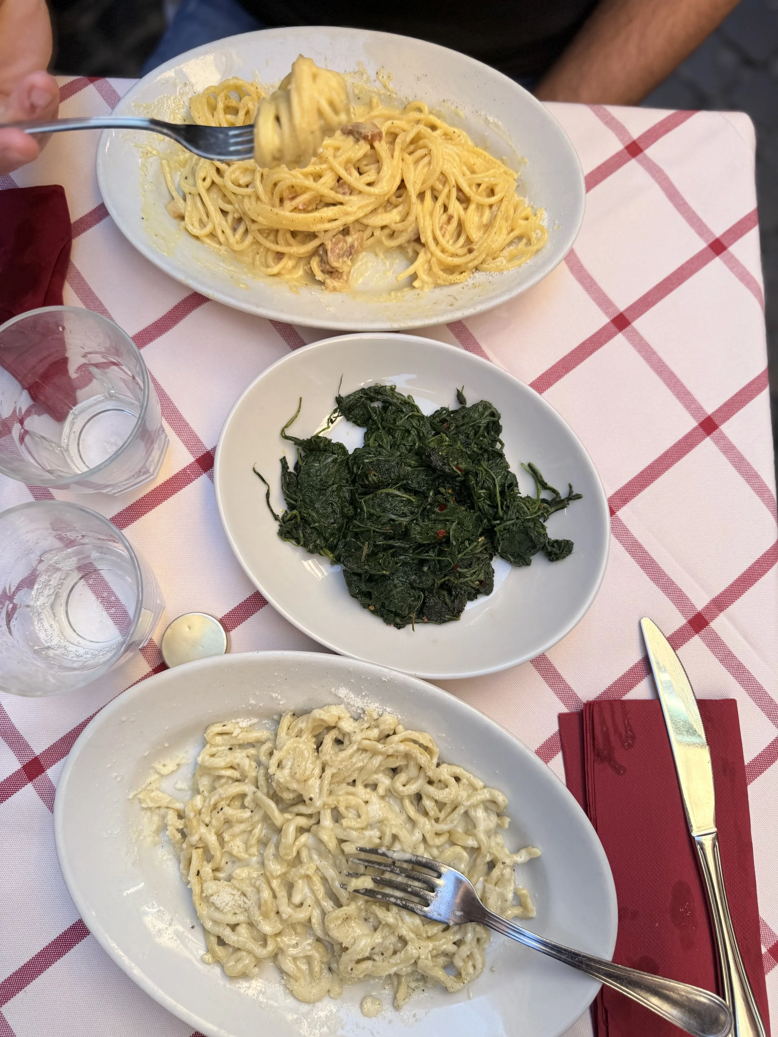 Local Italian trattoria table with cacio and pepe, cicoria and carbonara