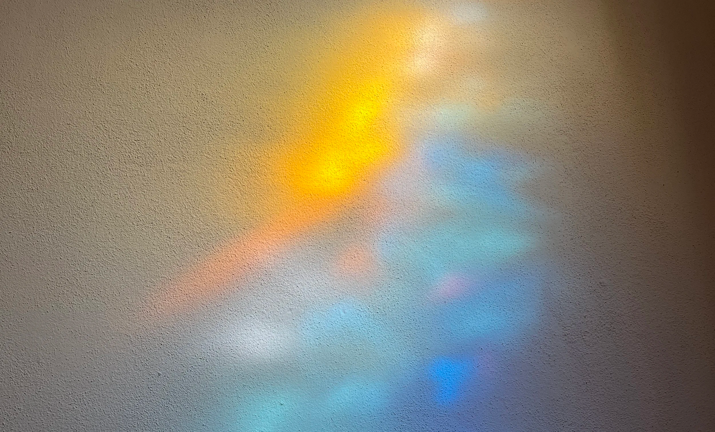 Farbiges Licht, das sich auf einer Wand spiegelt und der Künstlerin als Inspiration dient.