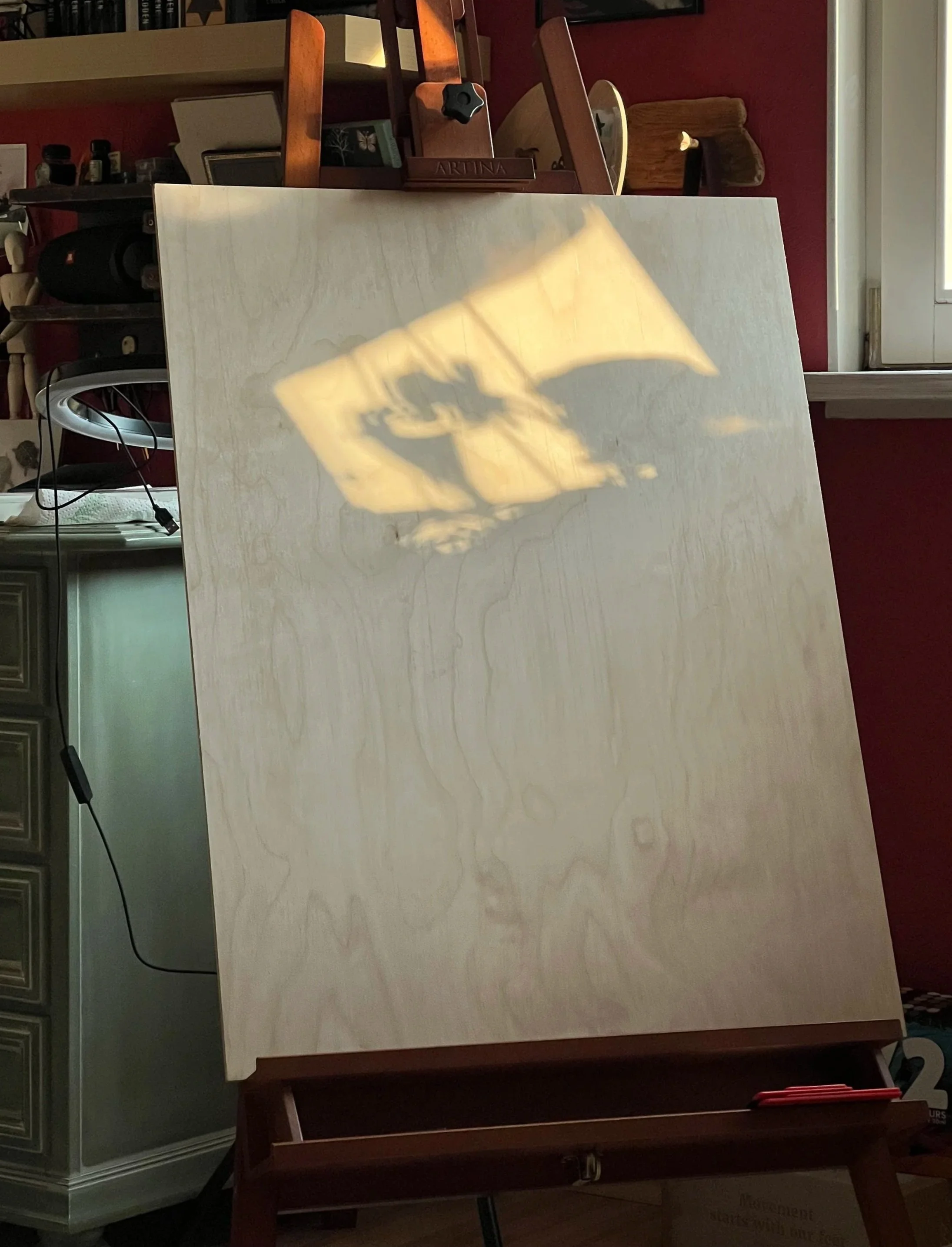 Ein Schattenbild auf einer Holzplatte, das stellvertrend für Inspiration steht, die man mit Aufmerksamkeit entdeckt.