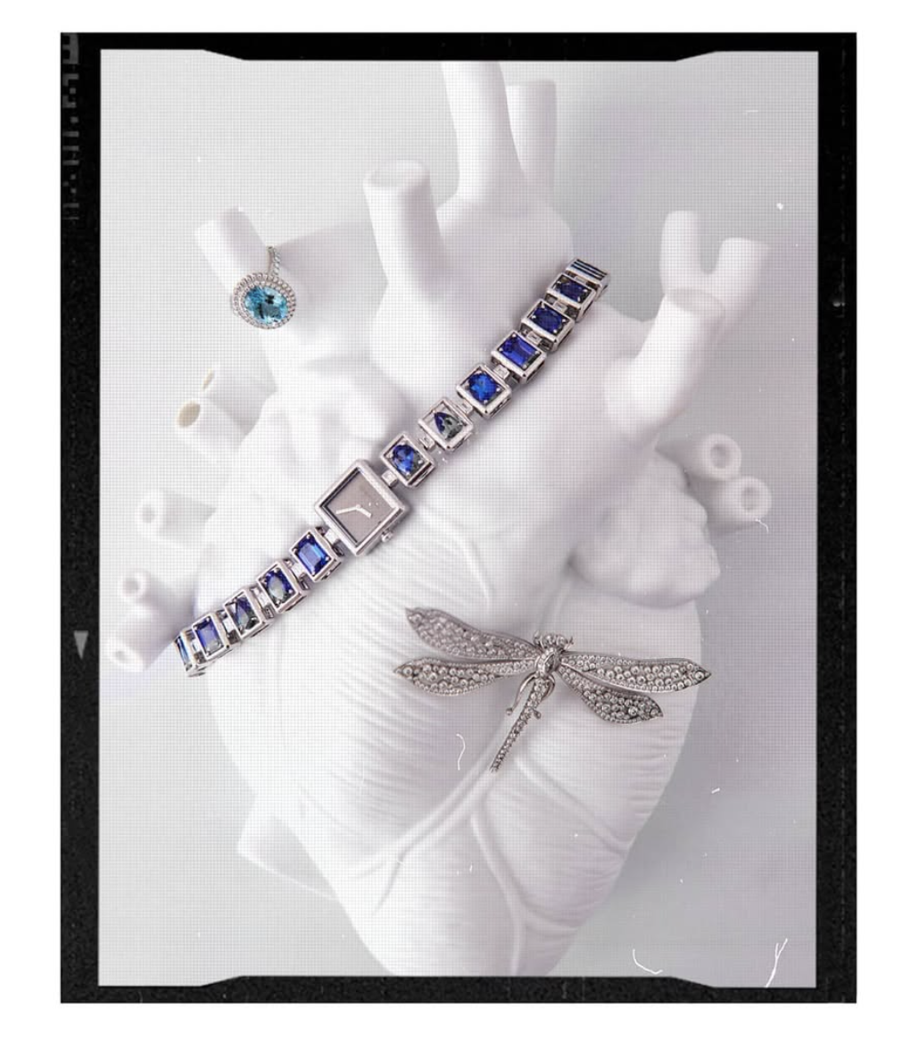 Jewelled bracelet and dragonfly brooch on a white sculpted hand, still life by To The Peak, Dubai