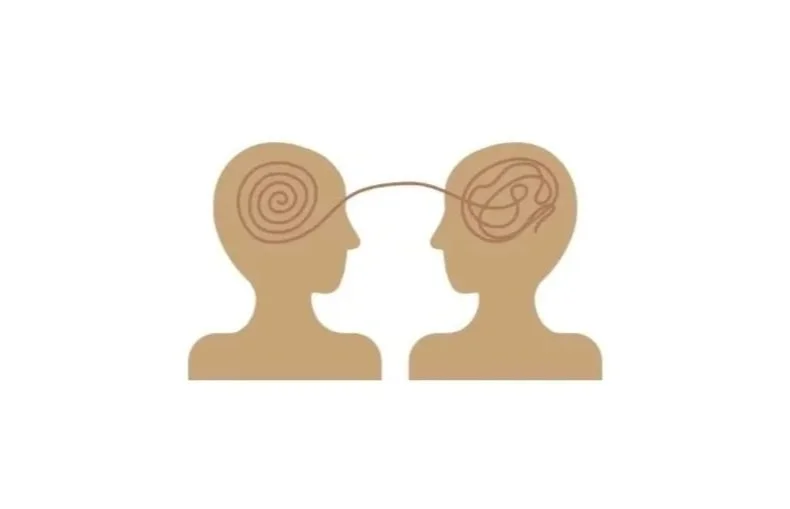Two human profiles facing each other with their brains connected by a line, each brain illustrated with spiral patterns.