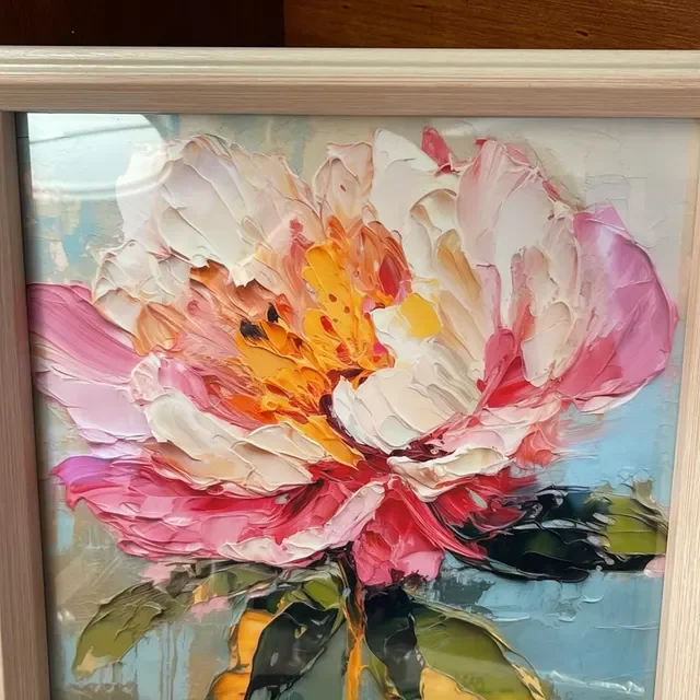 An abstract oil painting of a large peony flower with pink, white, yellow, and black petals and green leaves on a light blue background.