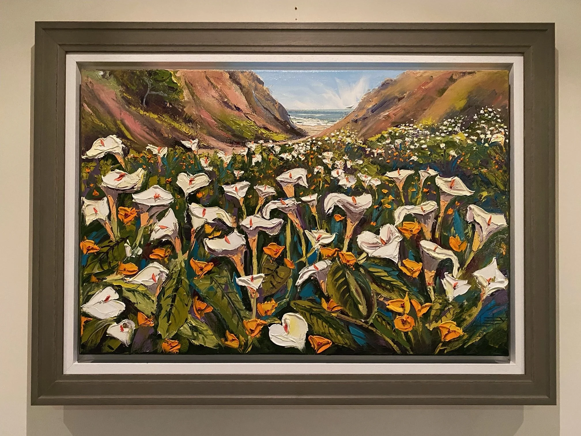 A landscape painting depicting a beach scene with cliffs on either side, a cloudy sky, and white flowers in the foreground.
