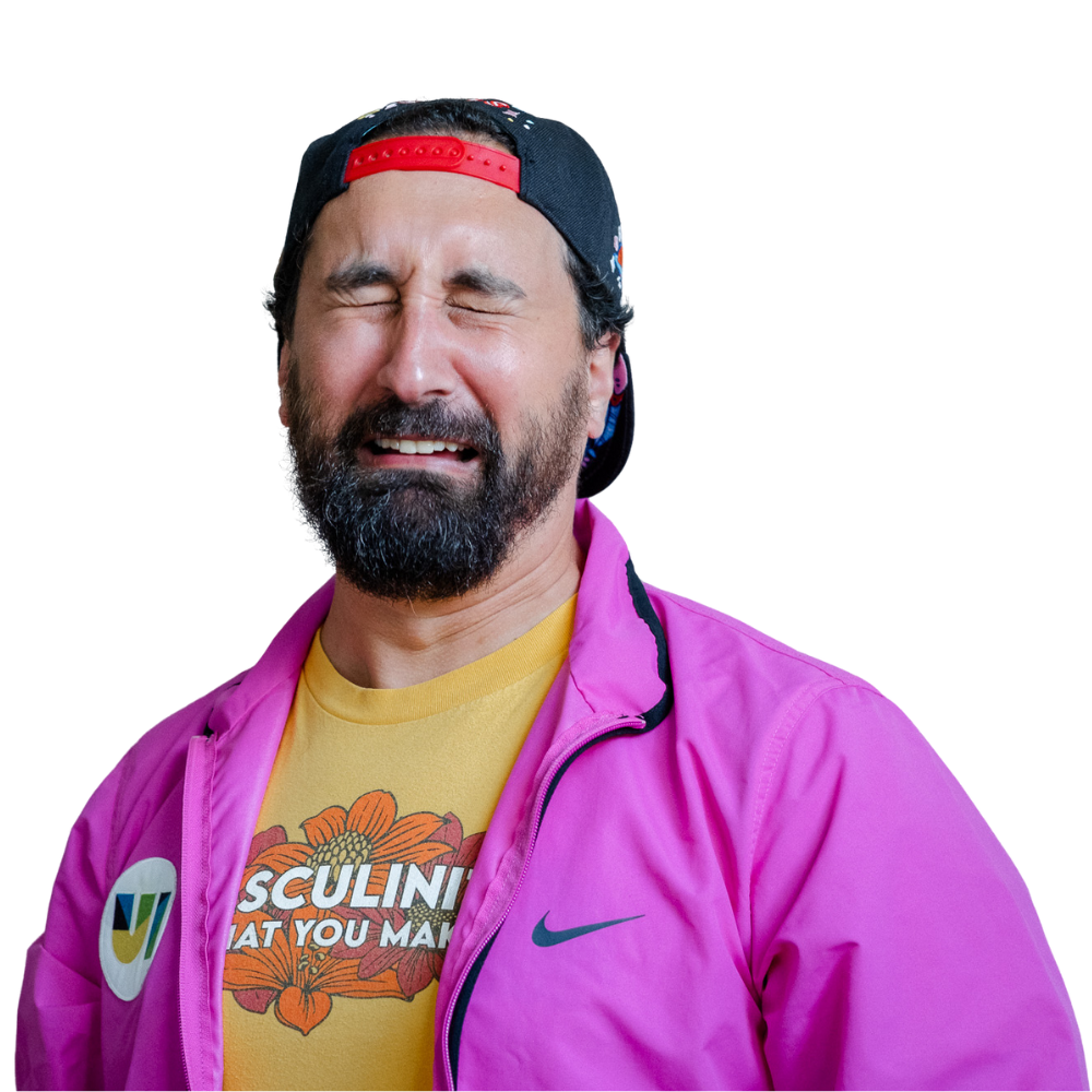 Greg Friend wearing a retro fuchsia windbreaker and a t-shirt that says "Masculinity is what you make it."