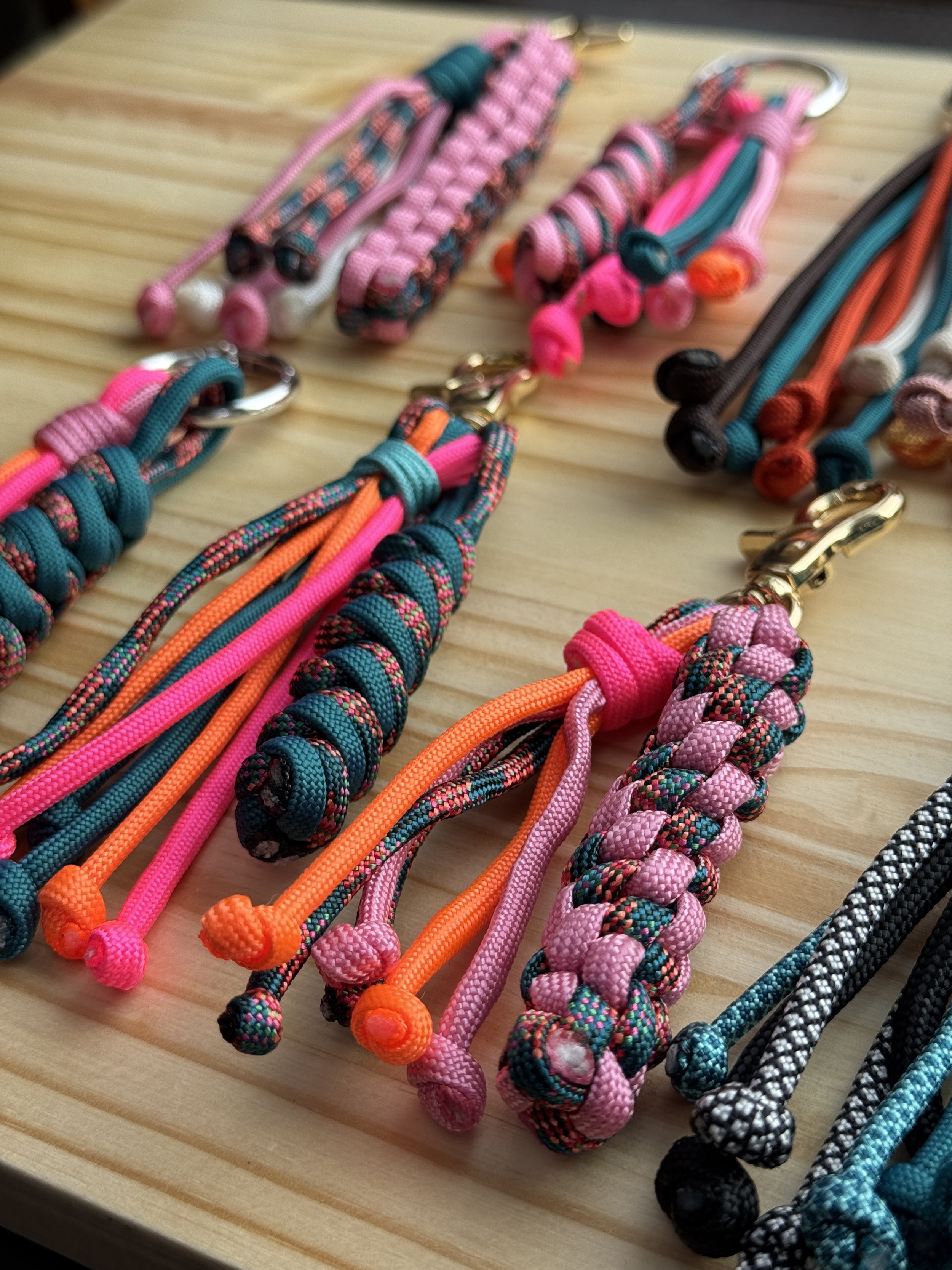 Paracord bag charms with box chain, snake chain, circle chain and tassels, with gold and silver hardware.